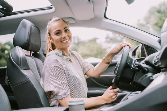 Happy young woman driving car