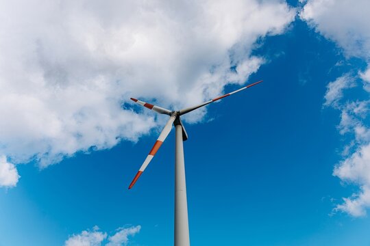 Wind turbine generating renewable energy against a blue sky