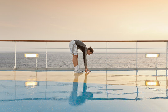 Young man doing exercises on a shipdeck, cruise ship, Mediteranean Sea