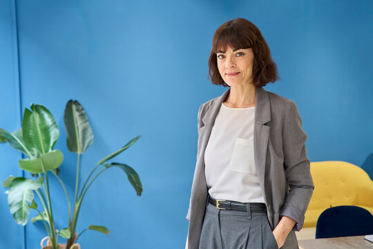 Confident business manager standing indoors looking at camera