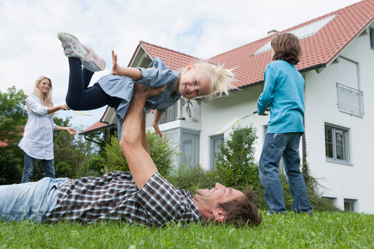 Germany, Munich, Family having fun in garden, smiling