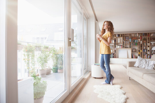 Woman at home looking out of window