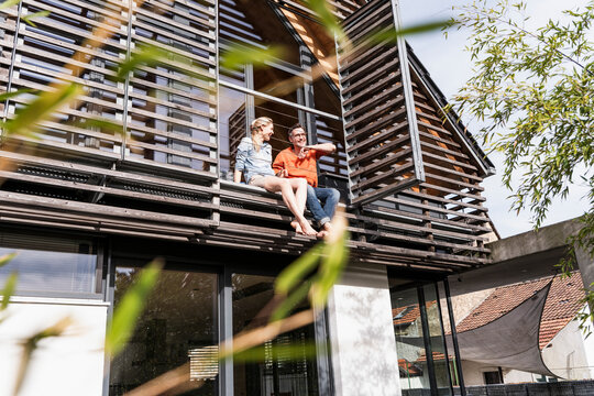 Mature couple relaxing together on balcony of their house