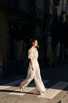 Woman crossing street on sunny day