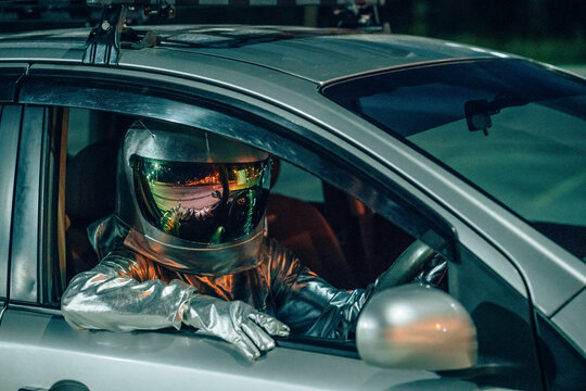 Spaceman sitting in car at night