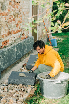 Man spreading cement on polystyrene in yard
