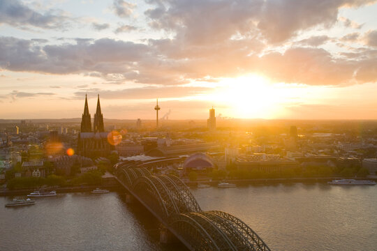 Aerial view of Cologne skyline with cathedral and bridge at sunset