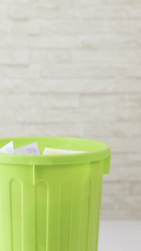 Throwing money into trash bucket