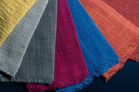 Colorful linen fabric swatches. Fan selection of textured linen fabric samples in various vibrant colors showing material quality for fashion, textile manufacturing, interior design, craft projects