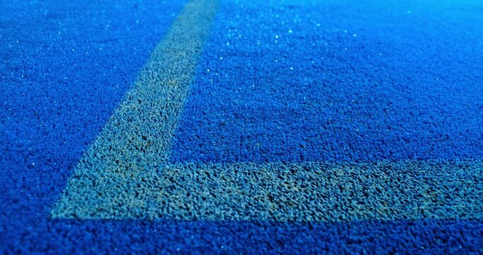 Extreme super slow motion close-up of a tennis or padel ball bouncing near the court line. Detailed blue surface texture captured at 1000fps with dynamic sports action in macro detail.