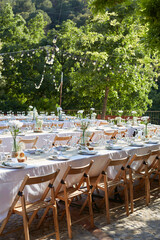 Obraz premium Vertical View of Outdoor Wedding Reception with Long Banquet Tables and String Lights