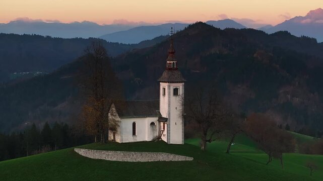 Sveti Tomaz, Slovenia - 4K Flying around St. Thomas Church (Cerkev Sveti Tomaz) on an autumn afternoon with Julian Alps at background at sunset