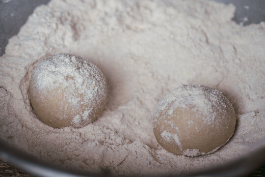 Macro shot of dough balls covered in flour. An abstract texture background of fresh, raw baking ingredients.