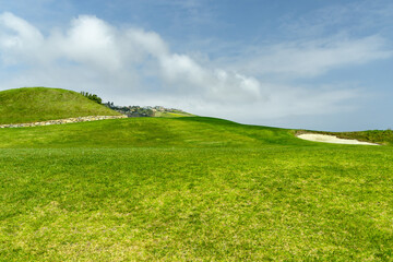 Obraz premium Green grass hill under blue sky minimal landscape background