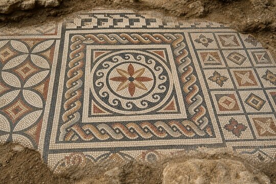 Close-up of ancient mosaic floor with geometric patterns, archaeological texture.