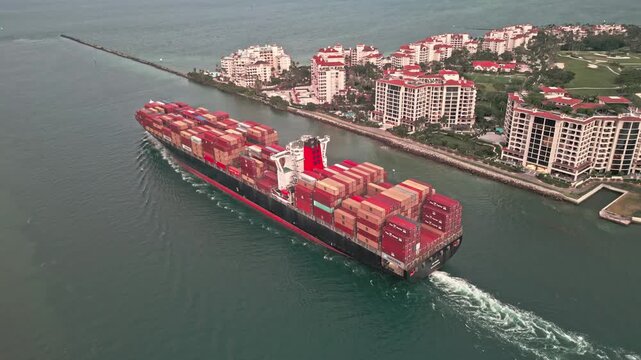 Miami, Florida, USA - June 17, 2024: Container ship. Cargo ship with container in Miami, drone view. Freight container loaded on cargo vessel in Miami. Aerial view cargo ship leaving port