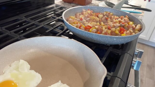 Stirring vegetable and sausage hash in frying pan