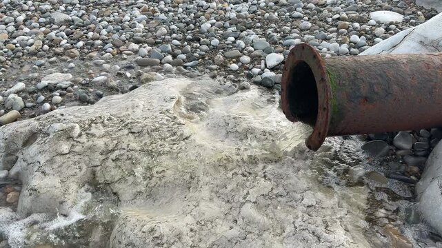 Water run off water from farmland and housing to the beach and sea large pipe taking it away England UK 4K