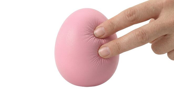 Fingers pressing into pink egg shaped squishy toy on transparent background