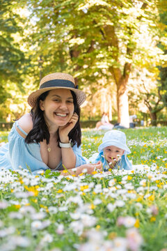 Smiling mother and baby in a flower meadow park Portrait