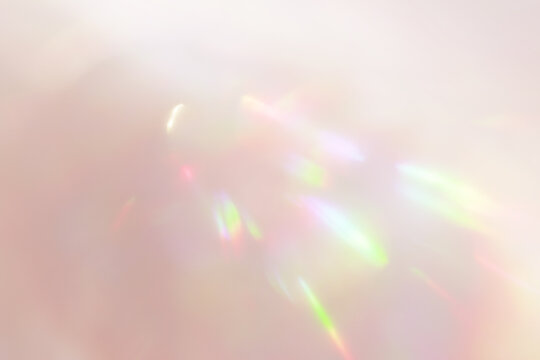 淡いオレンジに虹色が揺らめくホログラム光の抽象背景素材	