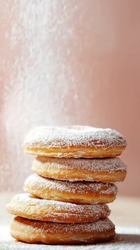 In a home kitchen, a stack of cookies is shown as powdered sugar is sifted over them. The cookies are round and lightly colored. The process is focused and hands are seen working gently