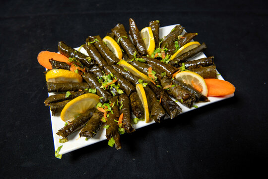 Doha, Qatar - Arabic Cuisine; Traditional delicious stuffed vine leaves. Served with yogurt salad and fresh lemon. Top view with copy space.