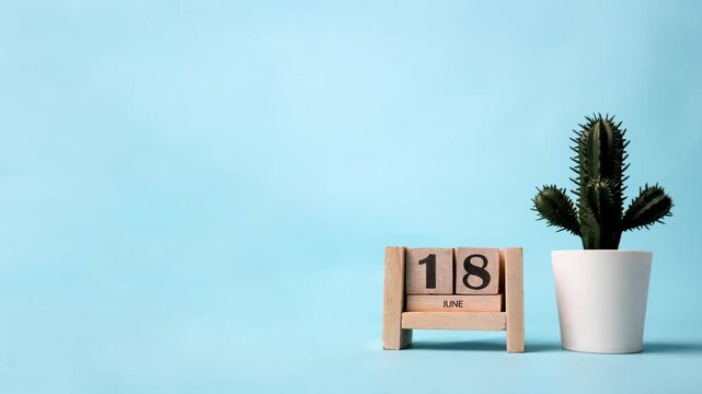 Month of June wooden block calendar timelapse with a plastic cactus on the side.
