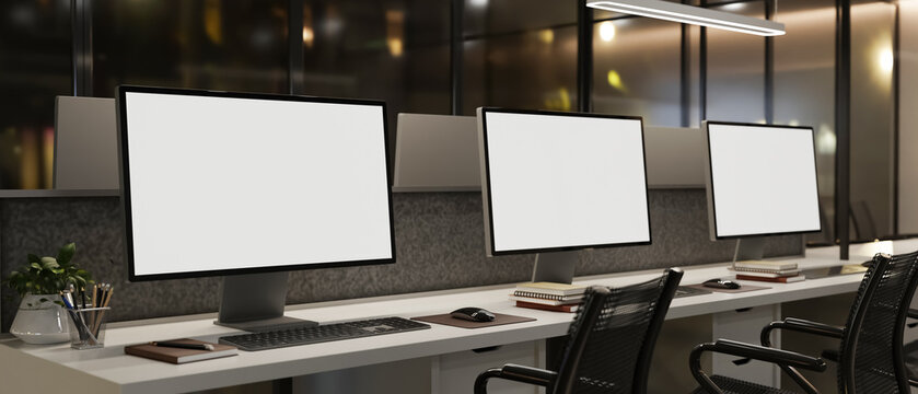 Modern office workspace with multiple desktop computer mockups