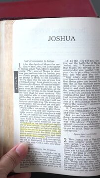 Opening to the Book of Joshua of the Old Testament in the Holy Bible. New Revised Standard Version. Vertical video.