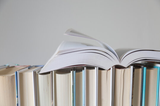 Libro aperto su fila di libri chiusi