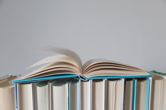 Libro aperto su fila di libri chiusi