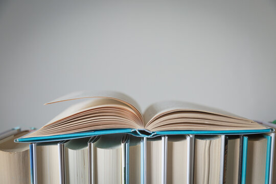 Libro aperto su fila di libri chiusi