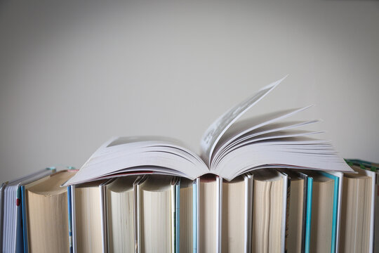 Libro aperto su fila di libri chiusi