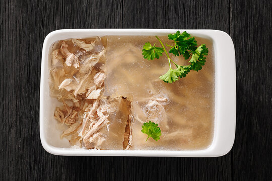 Cold meat aspic dish on dark wood table, close-up