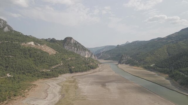 4K 10-bit drone shot flying forward low over a green river inside the giant rocky walls of Sahinkaya Canyon on a sunny day in Samsun, Turkey