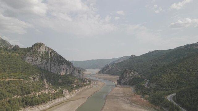 4K 10-bit drone shot flying forward low over a green river inside the giant rocky walls of Sahinkaya Canyon on a sunny day in Samsun, Turkey