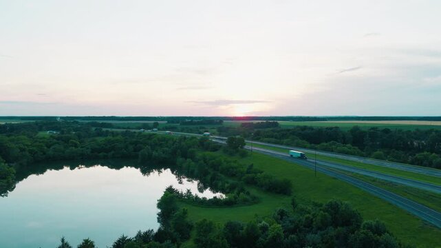 Semi trucks moving along Interstate 64 and crossing a rural overpass at dusk &mdash; ideal for logistics, freight shipping, supply chain and trucking campaigns. Richview, Illinois