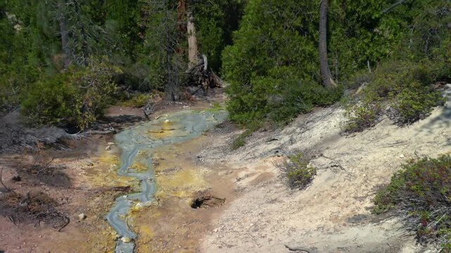 Bubbling mud pot and flowing geothermal stream in Lassen Volcanic National Park, California