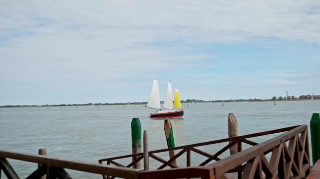 Dramatic rising high tide, known as acqua alta, in the venetian lagoon gradually submerging wooden dock piles and a pier