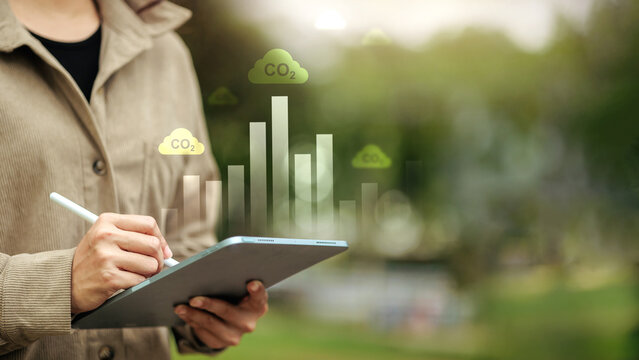 Business Professional Analyzing CO2 Emissions Data on Digital Tablet for Carbon Management and ESG Reporting