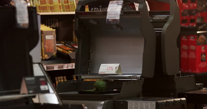 Modern black gas grills with open lids displayed on a shelf in a retail store interior