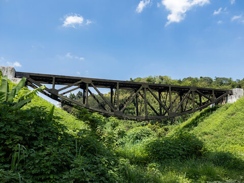 Historic inverted truss railway bridge over green valley