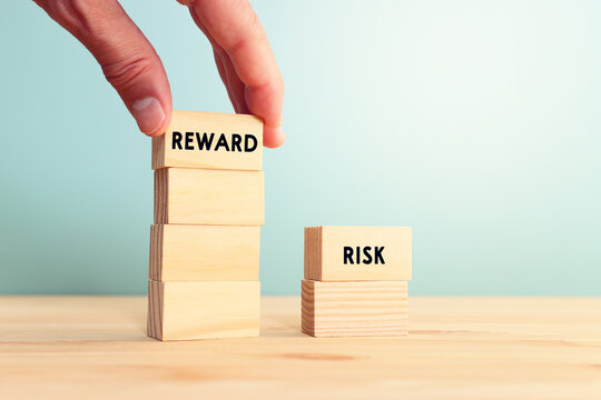 Wooden cubes with the words reward and risk on wooden table