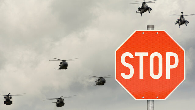 Stoppschild mit Milit&auml;rhubschrauber im Hintergrund