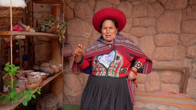Peruvian senior woman in traditional clothing spinning wool using a drop spindle