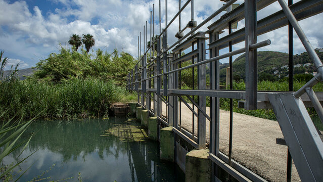 Steel sluice gate controls water flow in irrigation canal for rice paddies in Valencia Spain