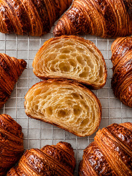 Freshly Baked Croissants with Flaky Cross Section on Cooling Rack