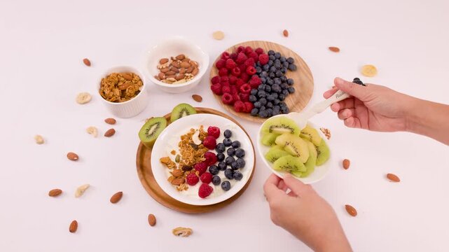 Overhead View of Hands Preparing Greek Yogurt Bowl with Fresh Fruit