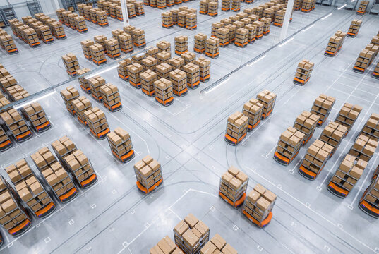Autonomous warehouse robots moving cardboard boxes across fulfillment center